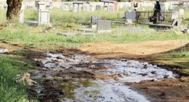 Image showing effluent leaking past and through gravesites at the Dundee cemetery.