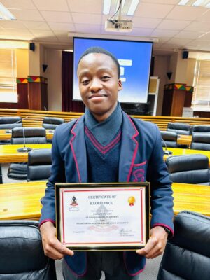 Image of Thulani Mncube, a learner that obtained the number one spot in the Zululand District on a tourism competition holding his certificate.