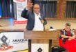 An Image of AbaQulusi Local Municipality Mayor, Sifiso Mkhwanazi standing at a podium, holding a micro-phone addressing ward committees at Cecil Emmett Hall.