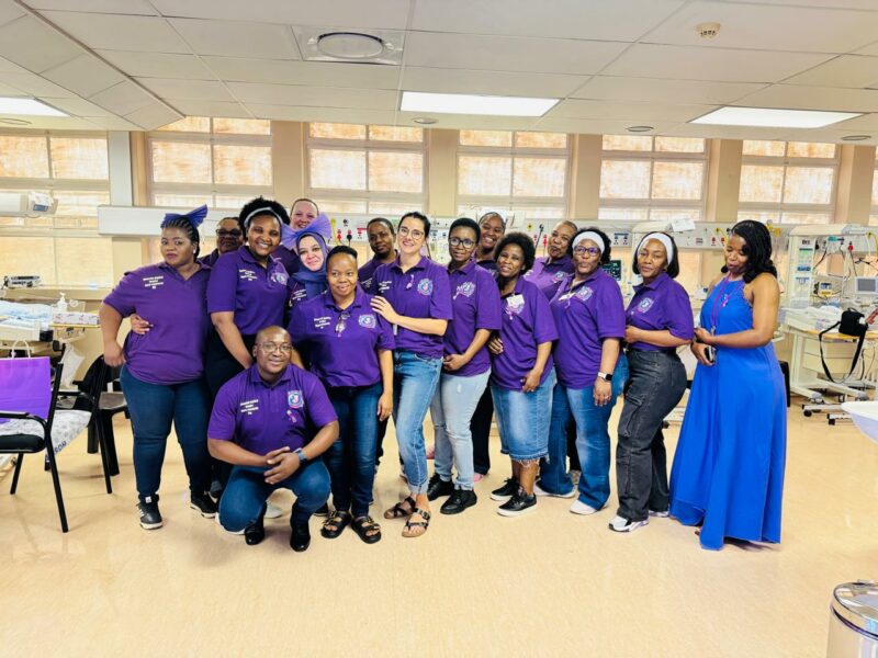A group of people dressed in purple pose for a photo for World Premature Day at the Newcastle Provincial Hospital.