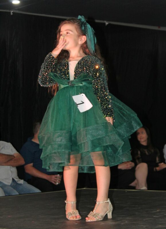 A young pageant queen dressed in beautiful evening wear on the Miss Wonder Woman Beauty pageant Stage in Newcastle.
