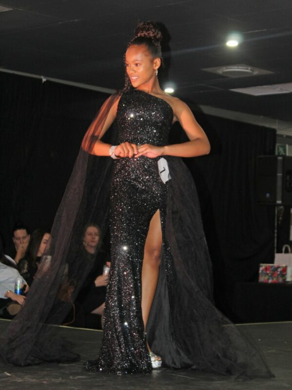 A young pageant queen dressed in beautiful evening wear on the Miss Wonder Woman Beauty pageant Stage in Newcastle.