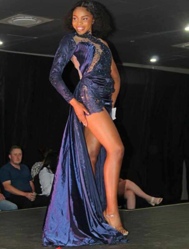 A young pageant queen dressed in beautiful evening wear on the Miss Wonder Woman Beauty pageant Stage in Newcastle.