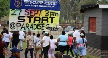 Participants walk towards the starting point of the Hippo-Campus Academy Colour Run at Paradise Grounds, beneath a large event banner.