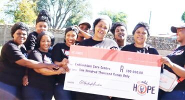 Image of KFC staff donating money to the Enhlanhlini Care Centre, Sibongile.