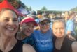 Image of four women, two with caps on, smiling after completing a trail run.