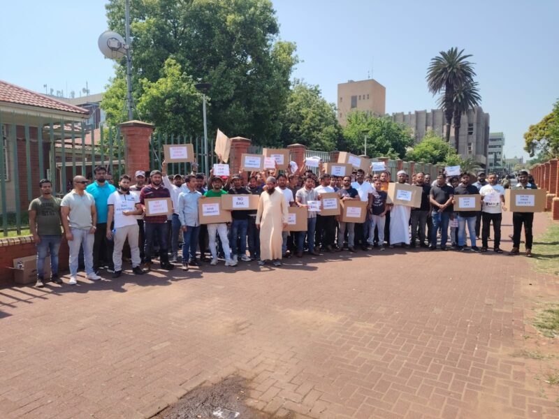 A large group of Bangladesh protestors stand with placards outside the Newcastle District Court.