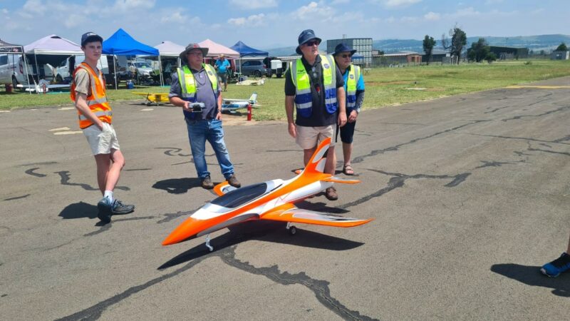 Three model aircraft pilots checking their plane at the Newcastle Airport.