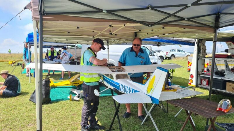 Two model aircraft pilots checking their plane at the Newcastle Airport.