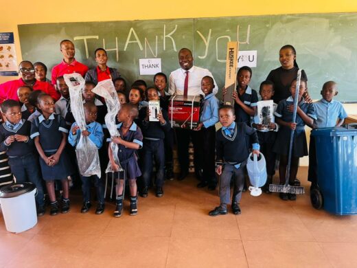 A group image of learners and staff members from Nkwambazi Primary School, holding garden equipment donated by EDTEA.