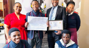 A group image of KwaNotshelwa High School learners and educators holding their certificate and cash-prize cheque.