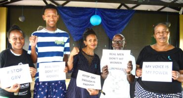 Image of Forestdale residents holding placards condemning GBV.