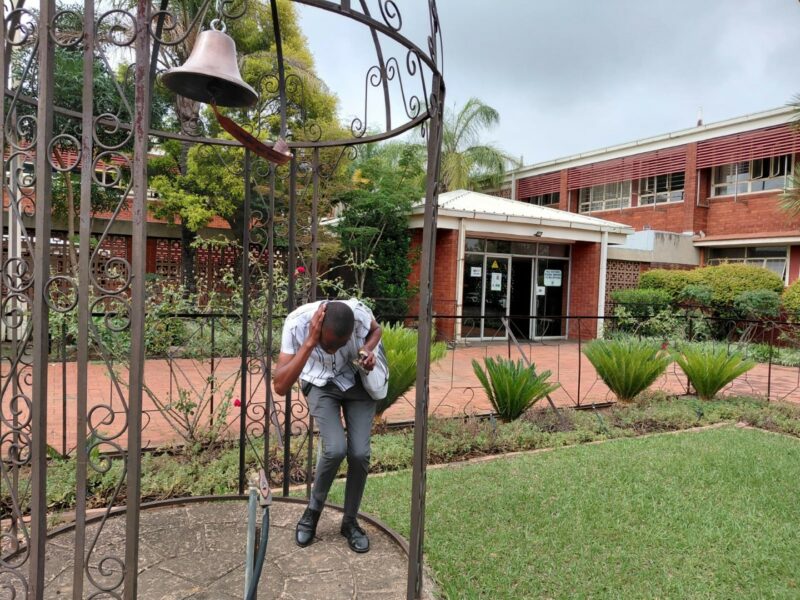 A photo showing learners from the Bridging Group 2025 taking turns to ring a ceremonial bell outdoors at Tugela Pre-Vocational School. Each photo features one or a small group of learners standing beneath the metal bell structure in a garden area with trees and school buildings in the background.