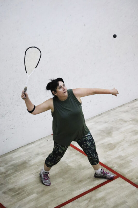 A squash player is captured in action on the squash court.