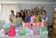 Several women are pictured posing behind a variety of sanitary items donated to the Newcastle Crisis Centre.