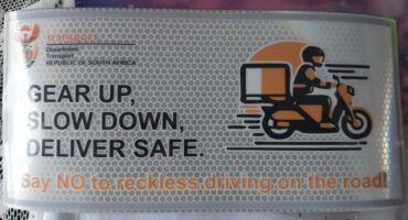 Image of sticker in white and orange that will go on delivery drivers' motorcycles.