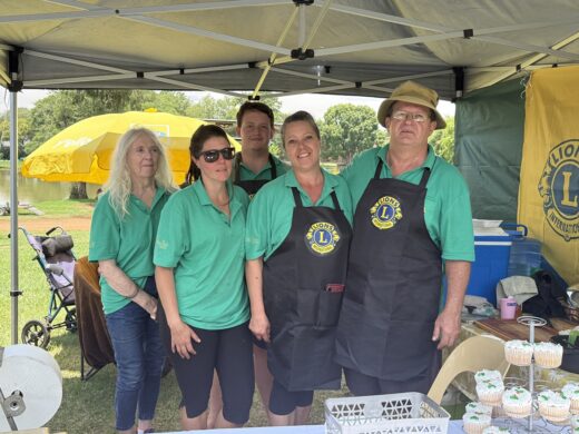 Image of men and women from Lions Club posing for a photo with aprons on.