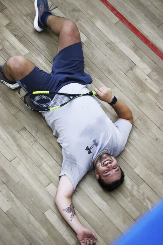 A squash player is captured in action on the squash court.