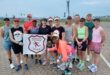 Image of all the runners after an early-morning long run, dressed in running gear and holding the Vryheid Athletic Club banner.