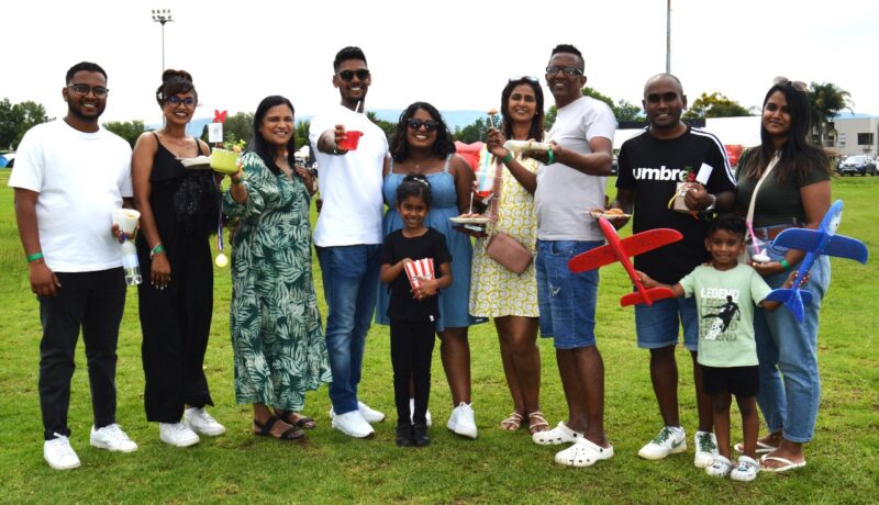 A group of people appearing to be very excited pose for a picture during a Christmas Bazaar.