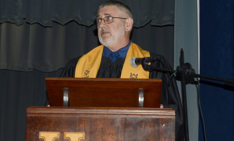 Image of Andries Gregory retiring teacher in academic gown.