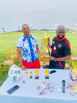 An image of the 'Shoe Donation Thanksgiving Tournament' organisers, holding a trophy with medals ready to crown the winners of the tournament.