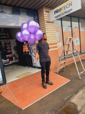 Image of a man holding purple balloons in Dundee as part of the GBV awareness campaign.