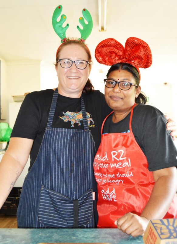 Two people appearing to be very excited pose for a picture during a Christmas Bazaar.