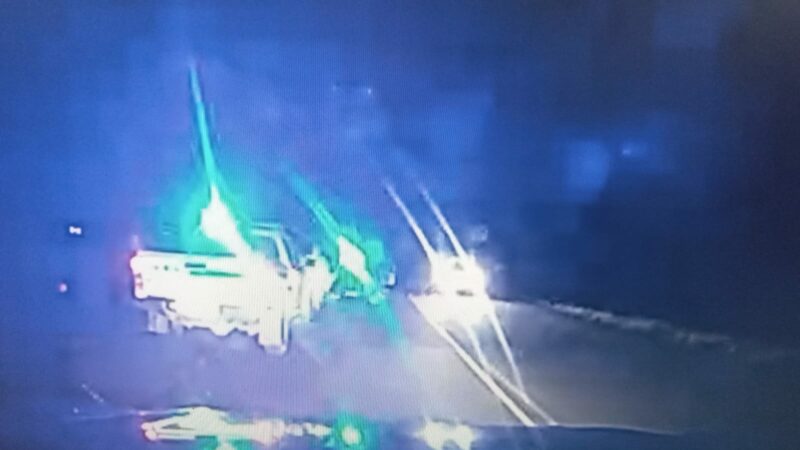 A photo of a crime scene. Law enforcement vehicles and blue lights can be seen in the photo.
