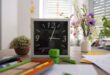 Desk with clock, stationery and flowers preparing for back to school.