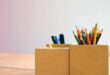 Coloured pencils and pens stored in wooden desk holders