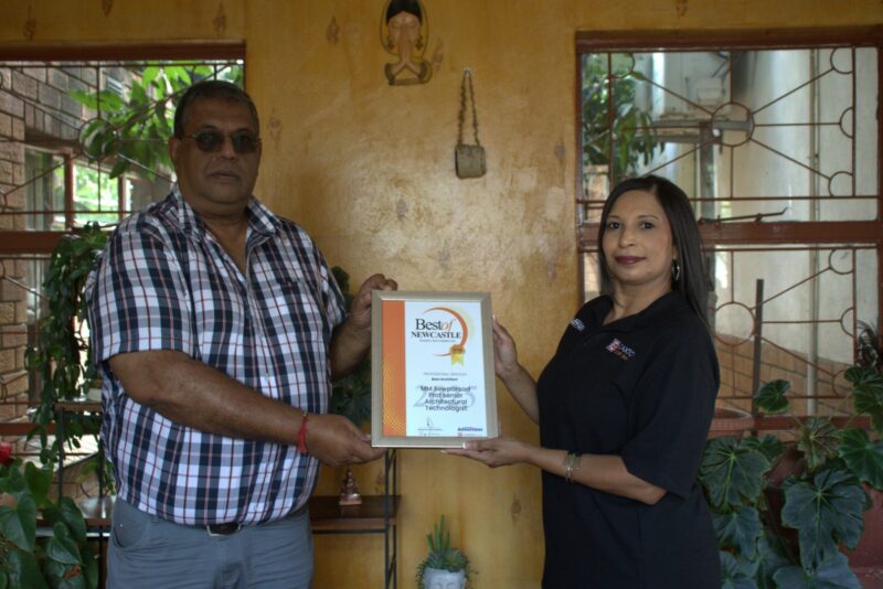 Newcastle Advertiser staff members hand over certificates to a Best of Newcastle Reader's Choice Award winner.
