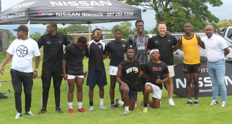 A team photo taken of rugby players posing with their sponsors, NTT Nissan Newcastle.