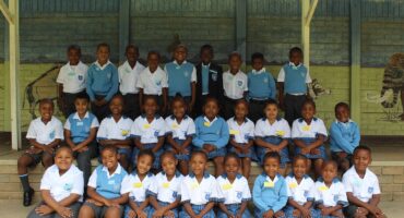 Image of group of grade 1 learners dressed in blue and white school uniform.