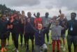 Image of men, women and children with their hands in the air celebrating after their parkrun.
