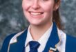 Image of female matric learner dressed in blue and white school uniform.