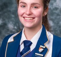 Image of female matric learner dressed in blue and white school uniform.