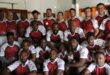 Image of rugby players in a group dressed in maroon and white rugby jerseys.