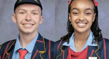 Twee Hoërskool Volksrust-leerders in skooldrag poseer as dubbele Dux.