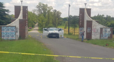 A white double cab Isuzu bakkie riddled with bullet holes stands still on a roadside in Newcastle.