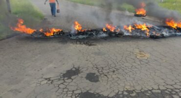 Image of burning tyres on a tar road in Glencoe.