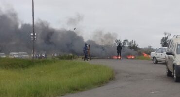 Image of burning tyres blocking entrance to Sithembile, Glencoe.
