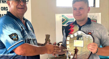 Image of Chairman Fritz Botes presenting a trophy to target shooting Junior Champion 2025, FC Eicker.