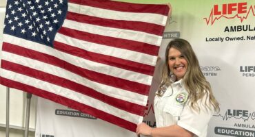 Chané Joubert holds a United States flag after graduating.
