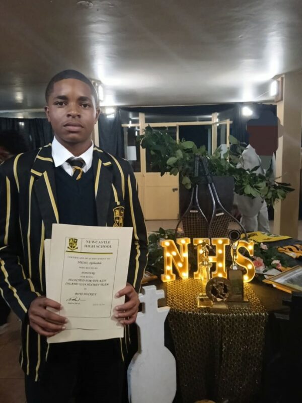 Sphesihle Khaba holds a Newcastle High School certificate at an awards ceremony.