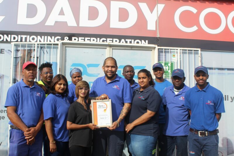 A group of people receiving a certificate from a Caxton Employee.