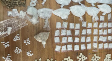 Various packets of narcotics pictured on wooden table at the police station.