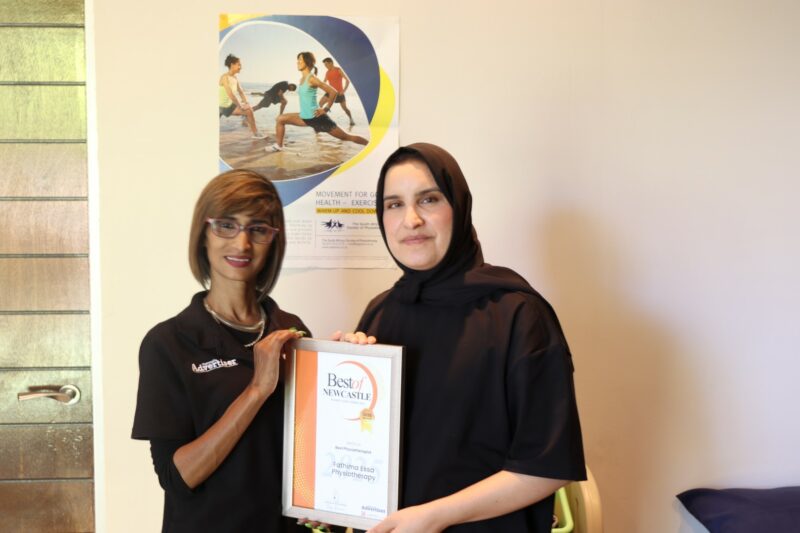 Two people holding an awards certificate for the Best of Newcastle Readers Choice Awards.