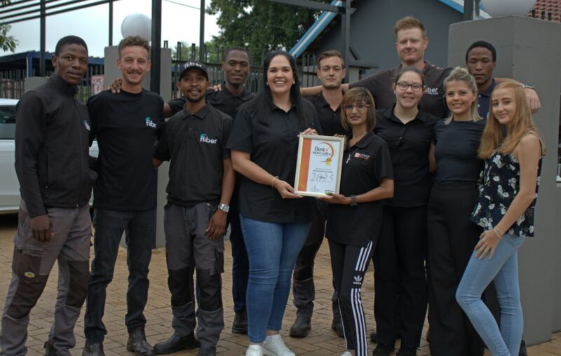 A group of people receiving a certificate from a Caxton Employee.