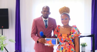 An image of Ayanda Kubheka handing over a gadget to Nonzuzo Ntshakala, she received the gadget from church members as she obtained three distinctions.